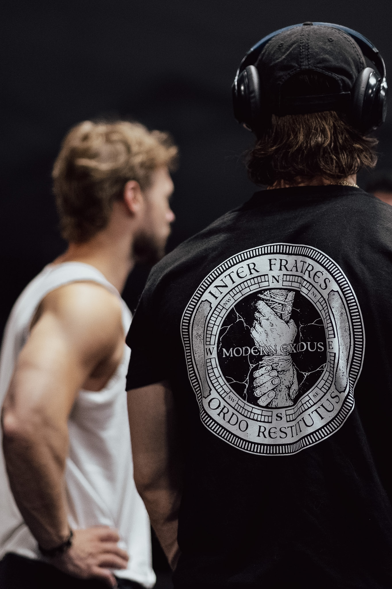 Black Modern Exodus shirt with its circular logo, photographed at a community event